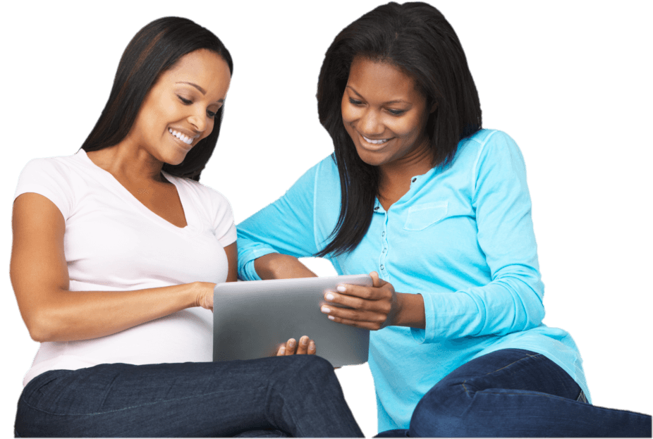 women smiling while looking on a gadget